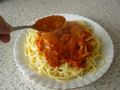 Spoon napolitana sauce over spaghetti Spoon napolitana sauce over spaghetti