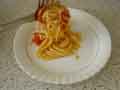 Spoon spaghetti onto hot plate